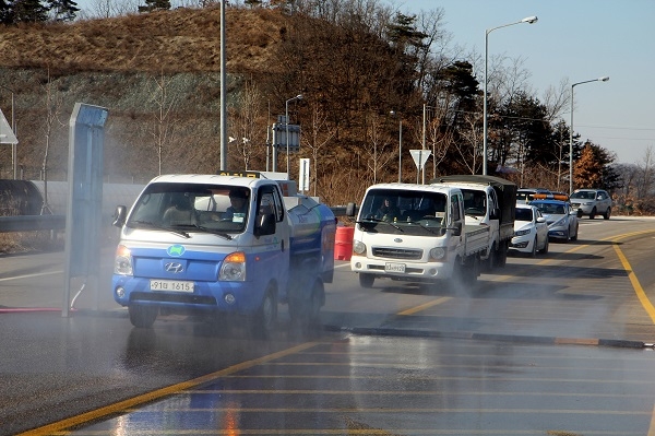 지난 14일 충북 보은군 탄부면 상장리 앞 국도 25호선을 지나는 차량들이 소독을 받고 있다. (사진=뉴시스 제공)