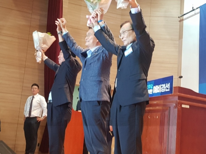 26일 국회의원회관 대강당에서 치러진 더불어민주당 당대표 예비경선에서 최종후보로 결정된 김진표·송영길·이해찬 의원이 나란히 서서 만세를 부르고 있다.