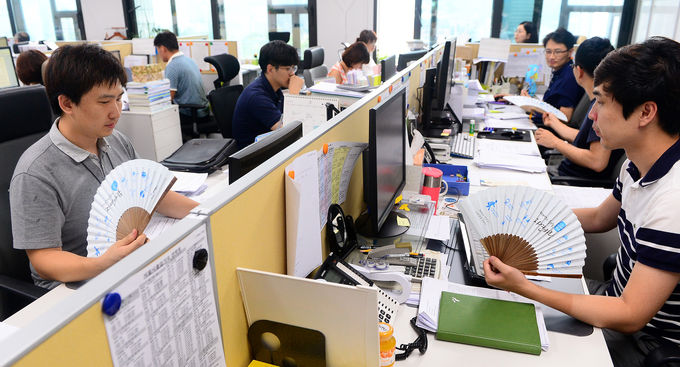 서울 중구 서울시청 서소문청사에서 '에어컨 설정온도 2도 올리기' 캠페인에 동참한 환경정책과 직원이 부채질을 하며 업무를 보고 있다.