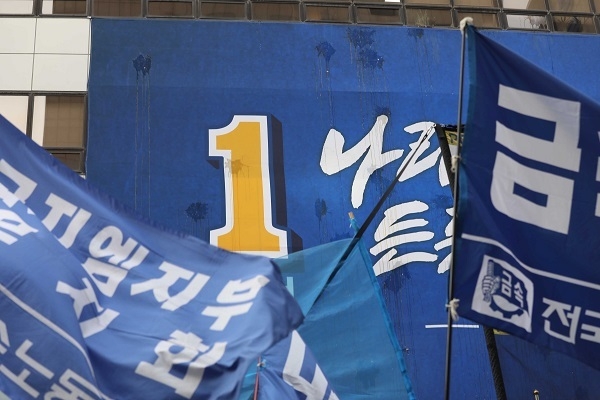 2018년 5월 28일 서울 여의도 더불어민주당 당사 앞에서 나부끼는 민주당 현수막(가운데)과 민노총 깃발.