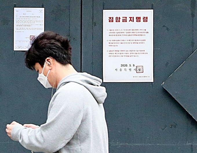 지난 연휴 기간 서울 이태원클럽을 방문하면서 코로나19에 감염된 확진자가 10일 정오 현재 54명으로 늘었다. 한 시민이 서울시의 집합금지 명령서가 부착된 강남의 한 클럽 앞을 지나고 있다(사진=뉴시스).