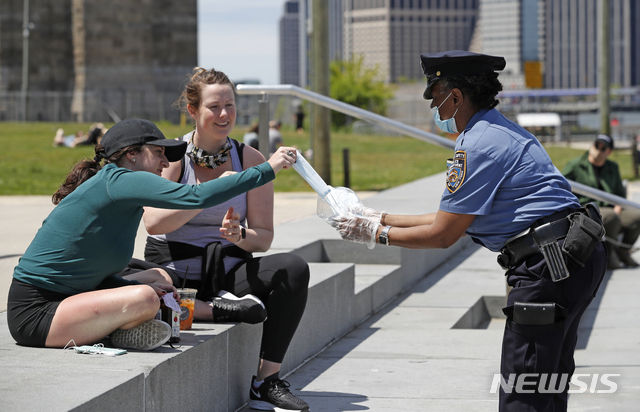 미국 뉴욕에서 뉴욕시경(NYPD) 학교안전과 경찰이 신종 코로나바이러스 감염증(코로나19)을 막기 위한 마스크를 시민들에게 나눠주고 있다. (사진=뉴시스)