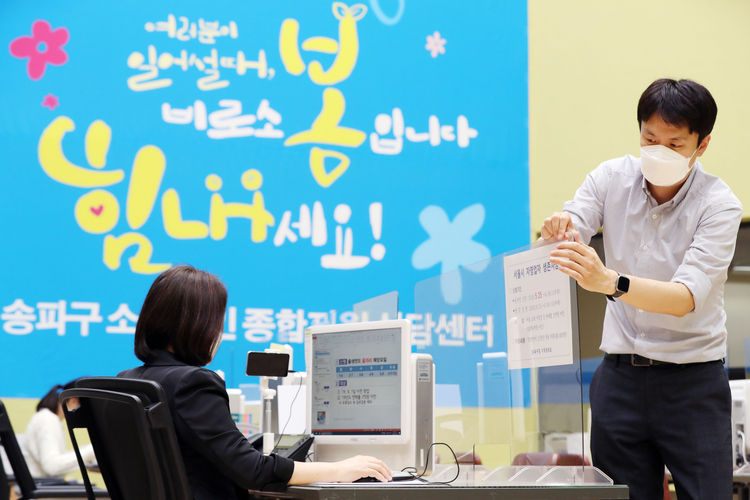 서울시 자영업자 생존자금 온라인 신청 등을 돕는 서울 송파구청 '송파구 소상공인 종합지원 상담센터'에서 22일 오후 송파구청 직원이 자영업자 생존자금 신청 안내문을 붙이고 있다. 서울시 자영업자 생존자금은 2019년도 연매출 2억 원 미만이면서 2019년 9월 1일 이전에 창업하여 실제 영업 중인 서울 소재 소상공인을 대상으로 별도의 지급자격 심사를 통해 월 70만 원씩 2개월 간 현금으로 지원하는 제도다. 온라인 신청은 오는 25일부터, 오프라인 신청은 6월 15일부터 30일까지 가능하다. 뉴시스 제공