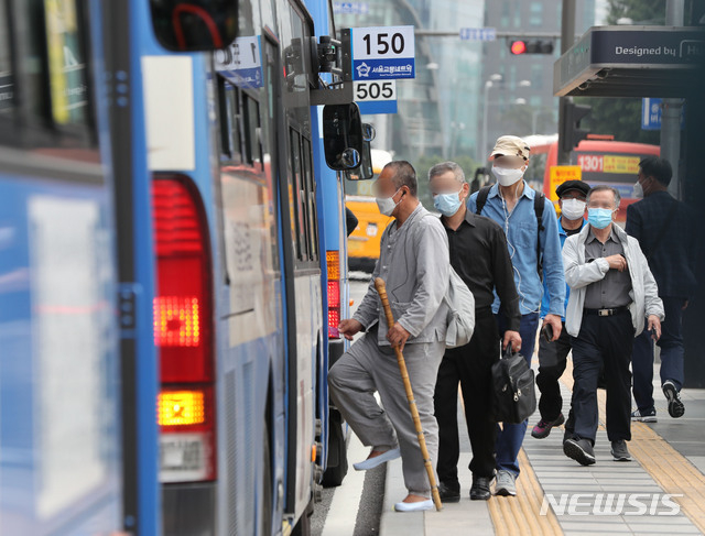정부가 오늘부터 승객이 버스나 택시를 탈 때 운송사업자와 운수종사자가 마스크를 착용하지 않을 경우 관할 시·도지사가 개선 조치를 내리도록 한 25일 오후 서울 용산구 서울역 인근 버스 정류장에서 시민들이 마스크를 쓰고 버스에 탑승하고 있다. (사진=뉴시스)