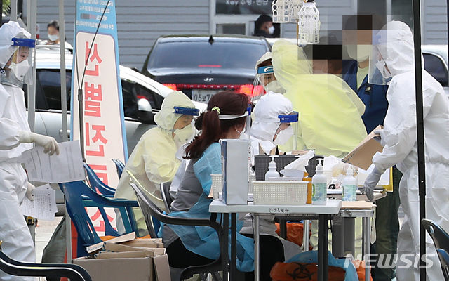 지난 27일 오후 인천시 계양구보건소 선별진료소에 검사를 받기위해 온 시민들이 의료진의 질문에 답하고 있다.(사진=뉴시스)