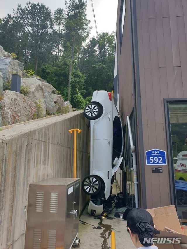 20일 오후 광주 동구 산수동 신양파크호텔 인근 모 커피숍 건물과 옹벽 사이로 K5 승용차가 끼여 추락하는 사고가 발생했다. 사고 직후 모습. (사진=광주 지산119 안전센터 제공/뉴시스)