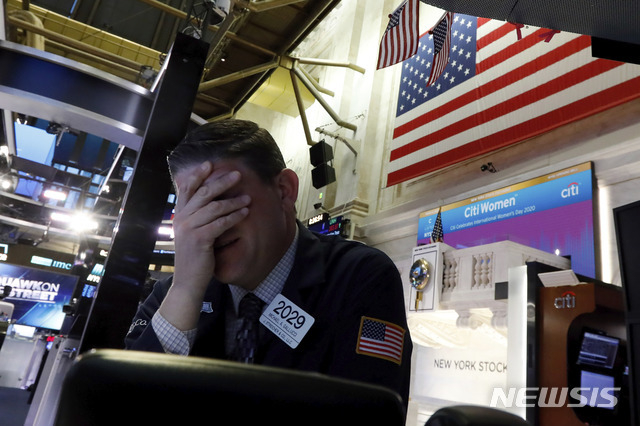지난 3월9일 증시가 폭락하자 뉴욕증권거래소(NYSE)에서 한 트레이더가 얼굴을 감싸고 있다.(뉴욕=AP/뉴시스)