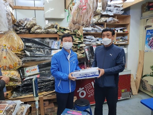 문성혁 해양수산부 장관 (아래사진 좌)과 홍진근 수협중앙회 대표(위 사진 우)이 서울 노량진수산시장 내 진남상회에서 물건을 구입 후 격려하고 있다.