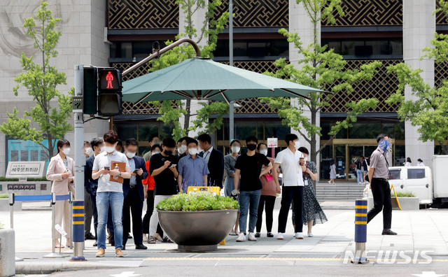 0도 넘는 무더위 날씨를 보이는 8일 오후 서울 종로구 광화문광장 햇빛 가림막 아래에서 시민들이 신호를 기다리고 있다.(사진/뉴시스)