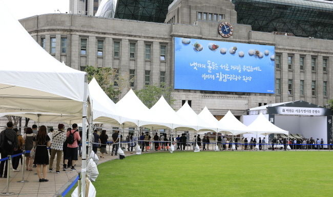 시민들이 12일 서울 중구 서울광장에 차려진 고 박원순 서울시장의 시민분향소에서 조문하기 위해 줄지어 기다리고 있다. 