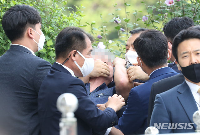 경호원들이 지난 16일 오후 서울 여의도 국회에서 열린 제21대 국회 개원식에 참석해 개원 축하 연설을 마친 문재인 대통령을 향해 신발을 던지고 돌발 발언을 한 시민의 입을 막고 있다.(사진/뉴시스)