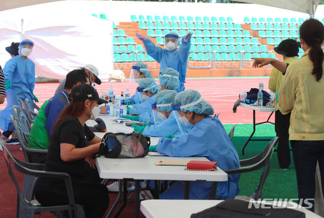 코로나19 감염이 이어지고 있는 17일 오전 제주시 한림읍 한림체육관에 마련된 워킹스루 선별진료소에서 주민들이 검체검사를 받고 있다. (사진/뉴시스)