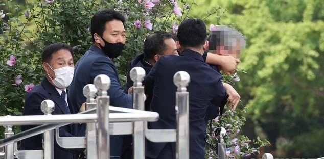 경호원들이 지난 16일 오후 서울 여의도 국회에서 열린 제21대 국회 개원식에 참석해 개원 축하 연설을 마친 문재인 대통령을 향해 신발을 던지고 돌발 발언을 한 시민의 입을 막고 있다.