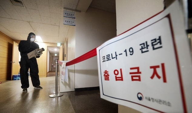 25일 오전 서울 종로구 청사 개인정보보호위원회 사무실 앞에서 방역 관계자가 방역 소독을 하고 있다.