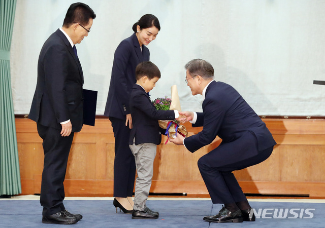 문재인 대통령이 29일 청와대 본관에서 박지원 신임 국가정보원장에게 임명장을 수여한 후 박 국정원장의 손자에게 꽃다발을 주고 있다. (사진=뉴시스 제공) 
