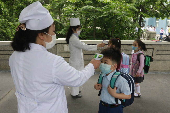 3일 북한 평양의 김성주 소학교 학교 학생들이 등교하면서 신종 코로나바이러스 감염증(코로나19) 예방을 위해 체온 검사를 받고 있다. 코로나19로 등교가 미뤄졌던 북한의 모든 학교가 이달 초 개학에 들어가면서 코로나19 방역에 박차를 가하는 것으로 알려졌다. (사진=뉴시스 제공)
