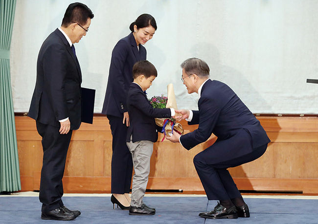 문재인 대통령이 지난 달 29일 청와대 본관에서 박지원 신임 국가정보원장에게 임명장을 수여한 후 박 국정원장의 손자에게 꽃다발을 주고 있다.(사진=청와대 제공)