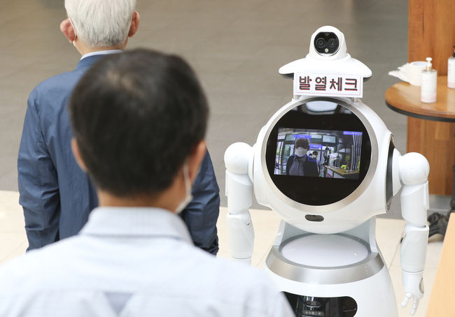 적외선 카메라와 안면인식 기술이 탑재된 인공지능(AI) 로봇이 지난 6월 4일 서울 서초구청 출입문에 배치 구청 출입자들의 체온 측정과 마스크 착용 유무를 확인하고 있다. (사진제공=뉴시스)