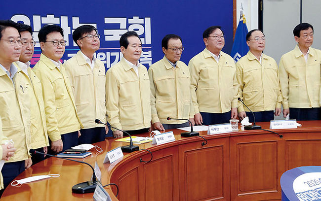 정세균 국무총리, 이해찬 더불어민주당 대표를 비롯한 참석자들이 12일 서울 여의도 국회에서 열린 고위당정협의회에서 기념촬영 준비를 하고 있다. 왼쪽부터 민주당 조정식, 윤호중, 박광온 의원, 김상조 청와대 정책실장, 정 총리, 이 대표, 김태년 민주당 원내대표, 홍남기 경제부총리 겸 기획재정부 장관, 진영 행정안전부 장관.