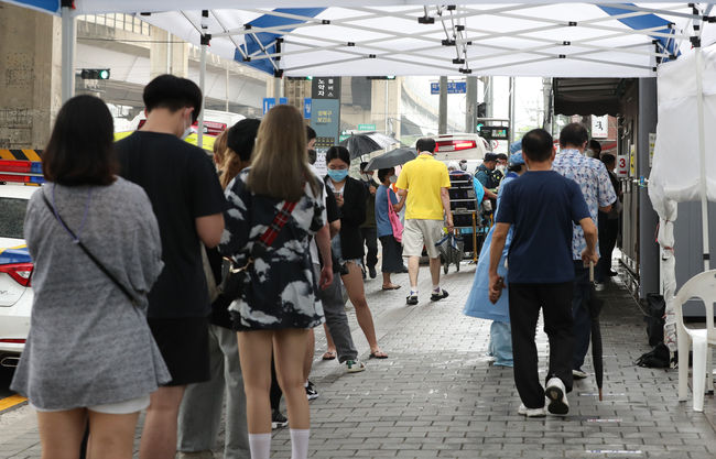 21일 오전 서울 성북구 보건소에 마련된 선별진료소에서 시민들이 코로나19 검사를 받기 위해 줄을 서 있다. (사진제공=뉴시스)