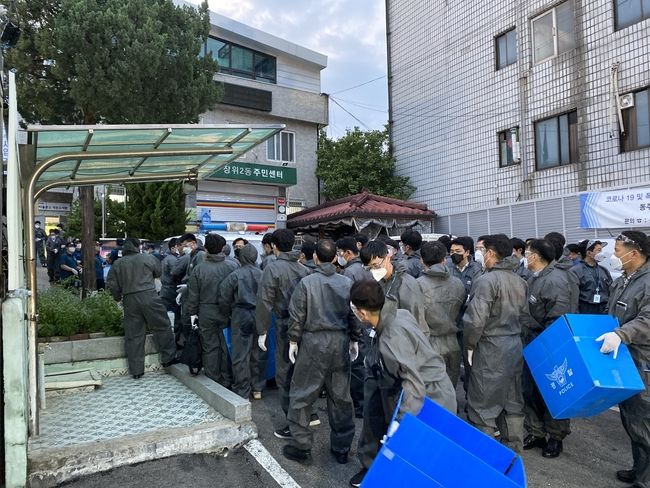 서울 성북구 장위2동 주민센터 주차장에 모인 경찰들이 사랑제일교회 교인 및 방문자 명단 확보를 위한 압수수색 전 파란 상자 등을 꺼내 대기하고 있다. (사진제공=뉴시스)