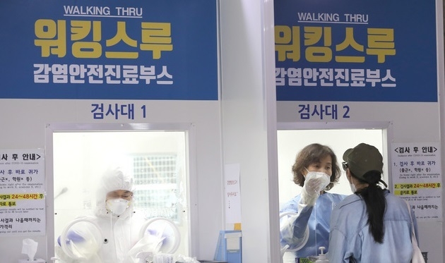 21일 오전 서울 성북구 보건소에 마련된 선별진료소에서 한 시민이 신종 코로나바이러스 감염증(코로나190 검사를 위한 검채를 채취하고 있다.
