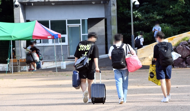 부산기계공고 기숙사에서 생활하던 2학년 학생 1명이 신종 코로나바이러스 감염증(코로나19) 확진 판정을 받은 12일 해운대구 해당 학교의 기숙사에 있던 학생들이 짐을 모두 챙겨서 귀가하고 있다. 사진제공=뉴시스