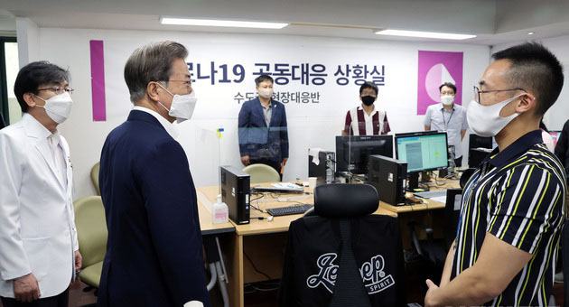 문재인 대통령이 28일 서울 중구 국립중앙의료원 수도권 병상 공동대응 상황실에서 주영수 국립중앙의료원 기획조정실장으로부터 중증 병상 확보 현황을 보고받은 뒤 관계자들을 격려하고 있다. (사진=청와대 제공)