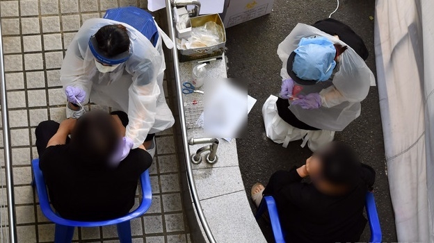 부산지역에 신종 코로나바이러스 감염증(코로나19) 확진자가 잇달아 발생하고 있는 가운데 24일 오후 부산진구 보건소 선별진료소를 찾은 시민들이 코로나19 진담검사를 위한 검체를 채취하고 있다.