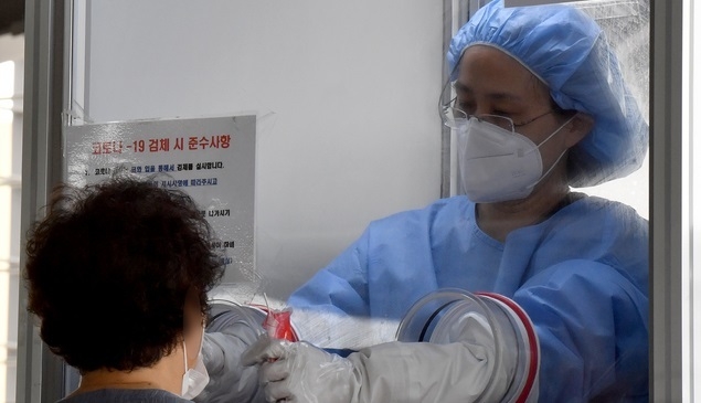 10일 오전 광주 북구보건소 코로나19 선별진료소에서 의료진이 진단 검사 대상자의 검체를 채취하고 있다.