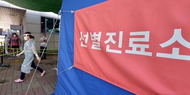 지난달 29일 대구 북구 소재 동우빌딩 지하1층에서 열린 동충하초 사업설명회가 코로나19 확산지로 지목되고 있는 가운데 4일 오전 대구 북구 침산동 북구보건소에 마련된 코로나19 선별진료소를 찾은 시민들이 검사를 받기 위해 줄을 서 있다.