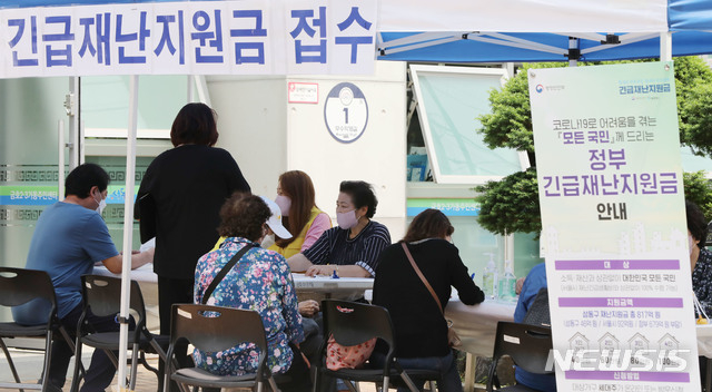 신종 코로나바이러스 감염증(코로나19) 대응을 위한 긴급재난지원금 현장 신청 첫 날인 지난 5월 18일 오후 서울 성동구 금호2.3가동주민센터에서 주민들이 신청서 접수를 하고 있다. (사진/뉴시스)