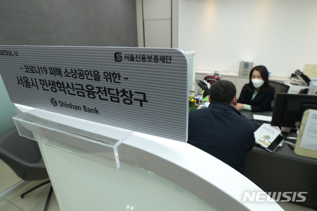 신종 코로나바이러스 감염증(코로나19) 여파로 피해를 입은 중소기업과 소상공인 지원을 위한 '서울시 민생혁신금융 전담창구' 운영을 시작한 6일 서울 중구 신한은행 본점에서 한 소상공인이 관련 상담을 받고 있다. 전담창구에서는 코로나19 피해기업 긴금경영안정자금(8000억원), 서울형 골목상권 119 긴급자금(2000억원), 서울형 이자 비용 절감 대환자금(600억원)에 대한 상담과 실제 지금 지원 등을 실시한다. (사진/뉴시스)