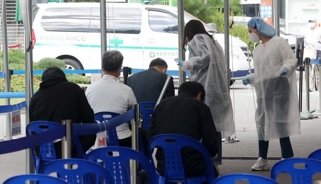 추석 연휴를 앞두고 신종 코로나바이러스 감염증(코로나19) 신규 확진자 수가 114명으로 확인된 25일 오전 서울 영등포구 영등포구보건소 선별진료소에서 코로나19 검사를 받으려는 시민들이 문진표를 작성하고 있다.