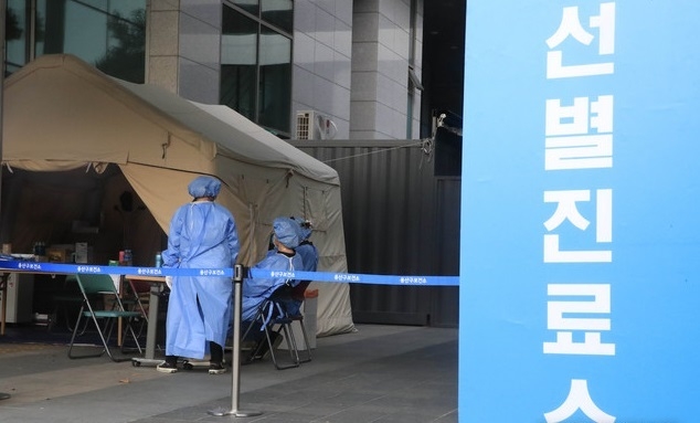 의료진이 지난달 28일 오후 서울 용산구 용산구보건소 신종 코로나바이러스 감염증(코로나19) 선별진료소에서 코로나19 검사를 받는 시민들을 기다리고 있다.