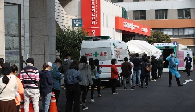 추석을 하루 앞둔 30일 오전 서울 중구 국립중앙의료원 코로나19 선별진료소에서 시민과 해외출국예정자 등이 검사를 받기 위해 줄서 기다리고 있다.