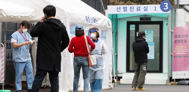 의료진이 16일 오후 서울 중구 국립중앙의료원에 마련된 선별진료소에서 내원객들에게 코로나19 검사 안내를 하고 있다.