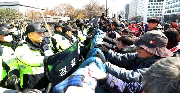지난해 4월3일 서울 영등포구 여의도 국회 정문에서 열린 민주노총 집회 참가자들이 국회 진입을 위해 담장을 허물고 있다.