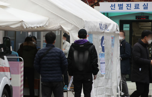 코로나19 신규확진자가 363명 늘어나며 사흘째 300명대를 넘긴 20일 오후 서울 중구 국립중앙의료원 선별진료소에서 출국예정자와 시민들이 코로나19 검사를 받기 위해 기다리고 있다 (사진=뉴시스)