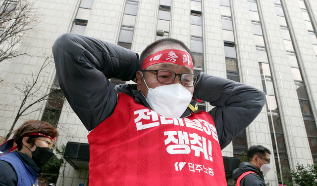 민주노총 조합원이 25일 오후 서울 여의도 더불어민주당 서울시당 앞에서 '노동개악 저지! 전태일3법 쟁취! 민주노총 총파업 총력투쟁 전국동시다발대회'에 참석해 머리띠를 두르고 있다. (사진=뉴시스 제공)
