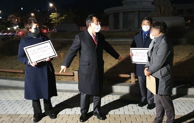 주호영 국민의힘 원내대표가 27일 청와대 앞에서 당 초선의원들의 질의서를 수령한 청와대 관계자와 대화하고 있다. 국민의힘 초선의원들은 질의서에 대한 답변과 면담 요청에 응하지 않아 릴레이 1인 시위를 이어가겠다고 밝혔다.