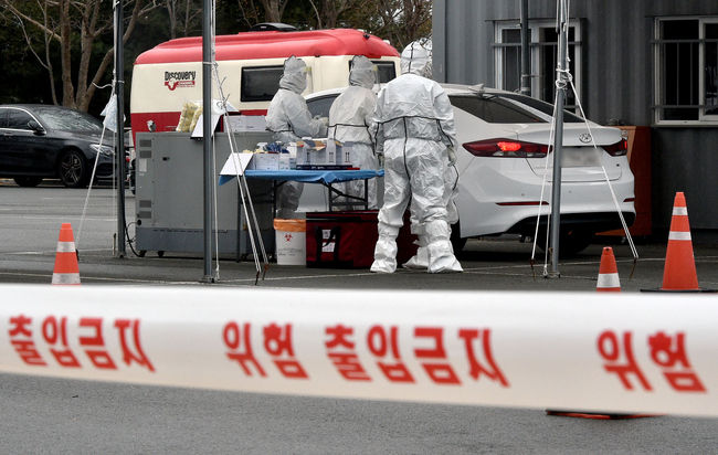 대구지역 신종 코로나바이러스 감염증(코로나19) 확진자가 12명으로 집계된 지난 24일 대구 수성구 대구스타디움 제3주차장에 마련된 드라이브스루 코로나19 임시선별검사소에서 의료진이 검체 채취를 하고 있다 (사진=뉴시스 제공)