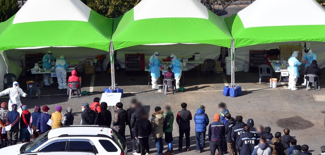 부산시는 4~8일 부산항운노조 23개 지부의 정규직과 임시직 근로자 총 9928명 명을 대상으로 전수검사를 진행하기 위해 '찾아가는 이동 선별검사소' 6곳을 운영한다고 밝혔다. 4일 오전 서구 부산공동어시장 주차장에 마련된 임시선별검사소를 찾은 항만근로자들이 길게 줄을 선 채 차례대로 검체를 채취하고 있다 (사진=뉴시스 제공)
