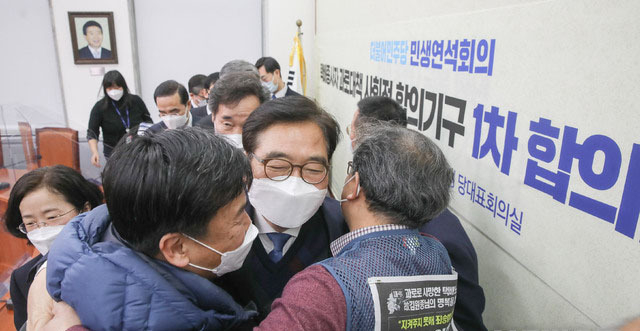 우원식 더불어민주당 민생연석회의 수석부의장이 지난 1월 21일 오전 서울 여의도 국회에서 열린 택배종사자 과로대책 사회적 합의기구 1차 합의문 발표식에서 택배노동자과로사대책위원회 관계자들과 포옹하고 있다. (사진=공동취재사진)