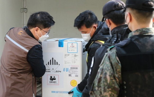 지나날 26일 오후 충남 천안실내배드민턴장에 마련된 신종 코로나바이러스감염증(코로나19) 중부권역 예방접종센터에 화이자사가 제조한 백신이 도착, 방역당국 관계자들이 차량에서 내리고 있다. (사진=뉴시스 제공)