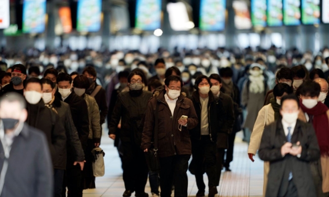 지난 1월8일(현지 시간) 일본 도쿄의 한 기차역에서 마스크를 쓴 출근길 시민들이 몰려나오고 있다. 스가 요시히데 일본 총리는 도쿄를 비롯한 3개 현에 코로나19 확산을 막기 위한 긴급사태를 선포해 8일부터 발효됐다 (도쿄=AP/뉴시스)