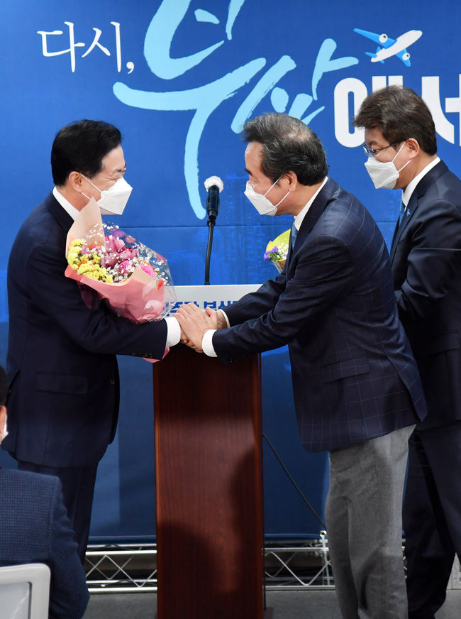  더불어민주당 부산시장 보궐선거 경선결과 발표대회가 열린 6일 오후 부산 연제구 민주당 부산시당에서 김영춘(왼쪽 두번쨰) 전 해양수산부 장관이 최종 후보로 선출된 이후 이낙연 대표로부터 축하 꽃다발을 받고 있다. / 사진제공=뉴시스