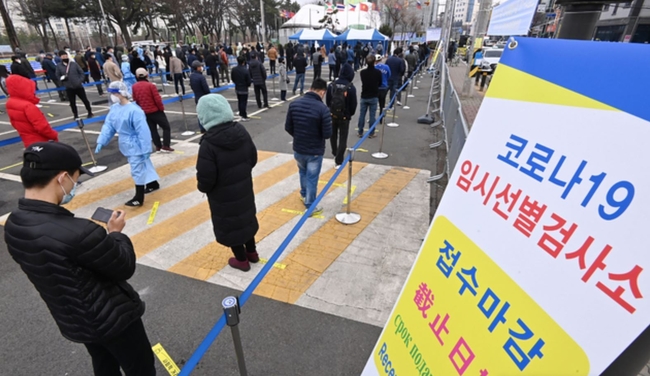 지난 21일 오전 경기도 안산시 단원구 외국인주민지원본부 인근에 설치된 임시선별검사소에서 외국인 근로자들과 시민들이 코로나19 검사를 받기위해 길게 줄 서 대기하고 있다 (사진=뉴시스 제공)