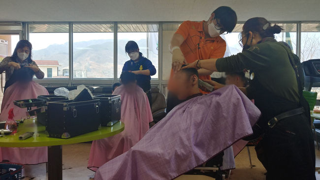 장애인시설 섬진강사랑의집 이용자에게 미용봉사활동을 펼치고 있는 모습