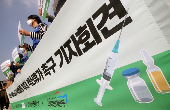 민주노총 공공운수노조 의료연대본부 조합원들이 25일 오전 서울 종로구 청와대 사랑채 앞에서 열린 '모든 병원·돌봄노동자에게 백신접종 확대와 백신휴가를 촉구하는 기자회견'에서 손피켓을 들고 있다.